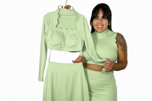 Woman wearing a light green outfit with matching jacket, top, and skirt on a white background
